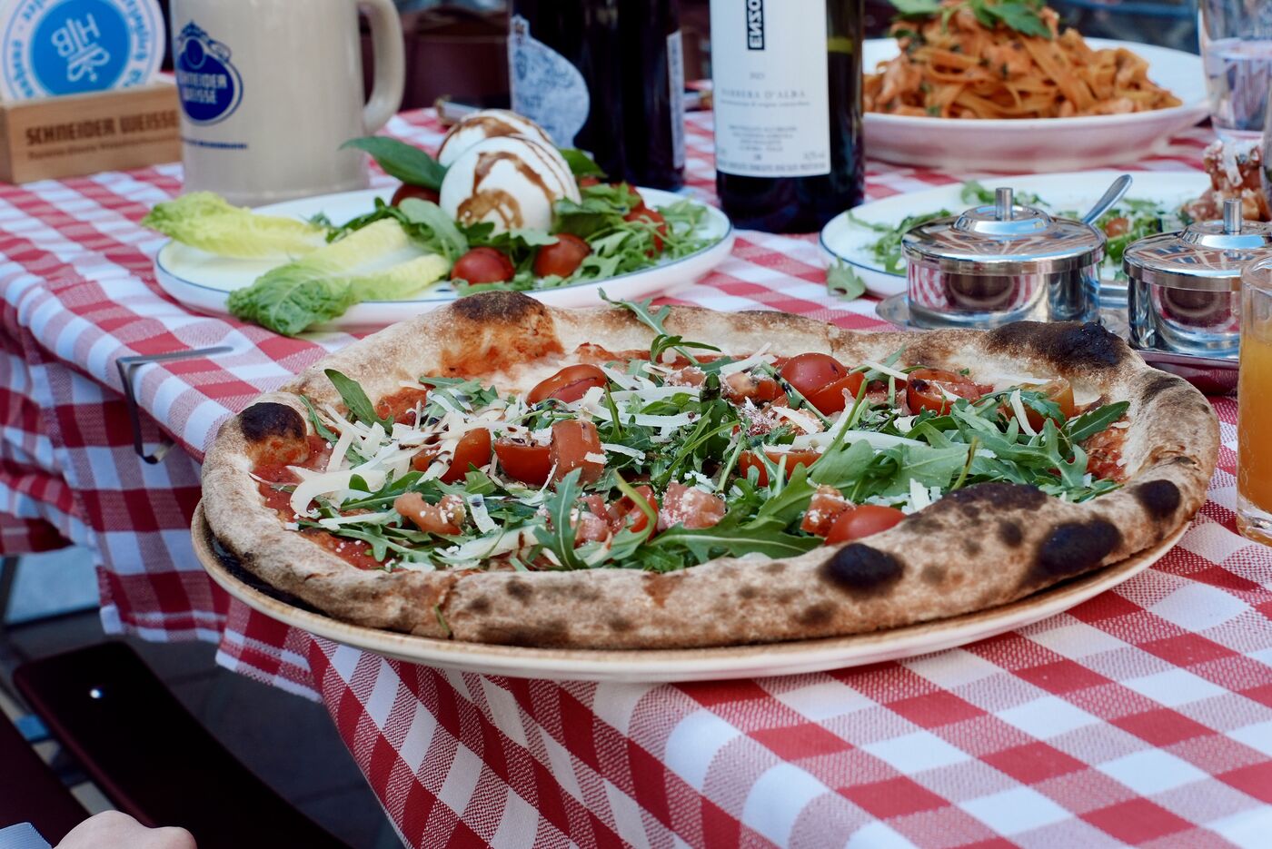 Pizza und Pasta auf kariertem Tisch